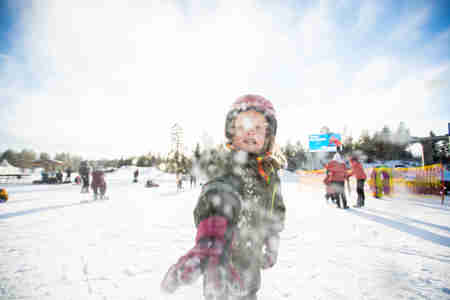 Barn som kastar snö mot kameran