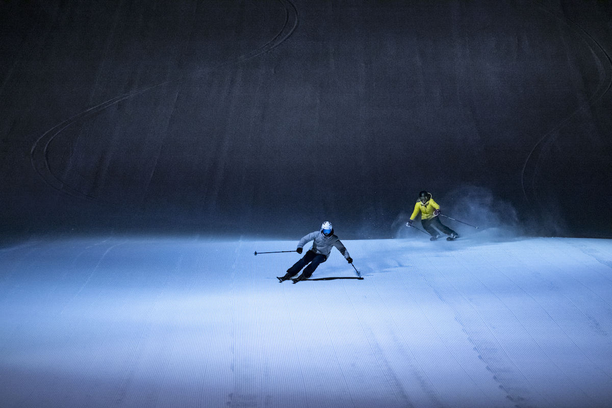 Slalomåkare i alpinbacke som åker i mörkret