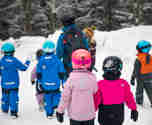 Aktivitetslärare som går med massor av barn i snön