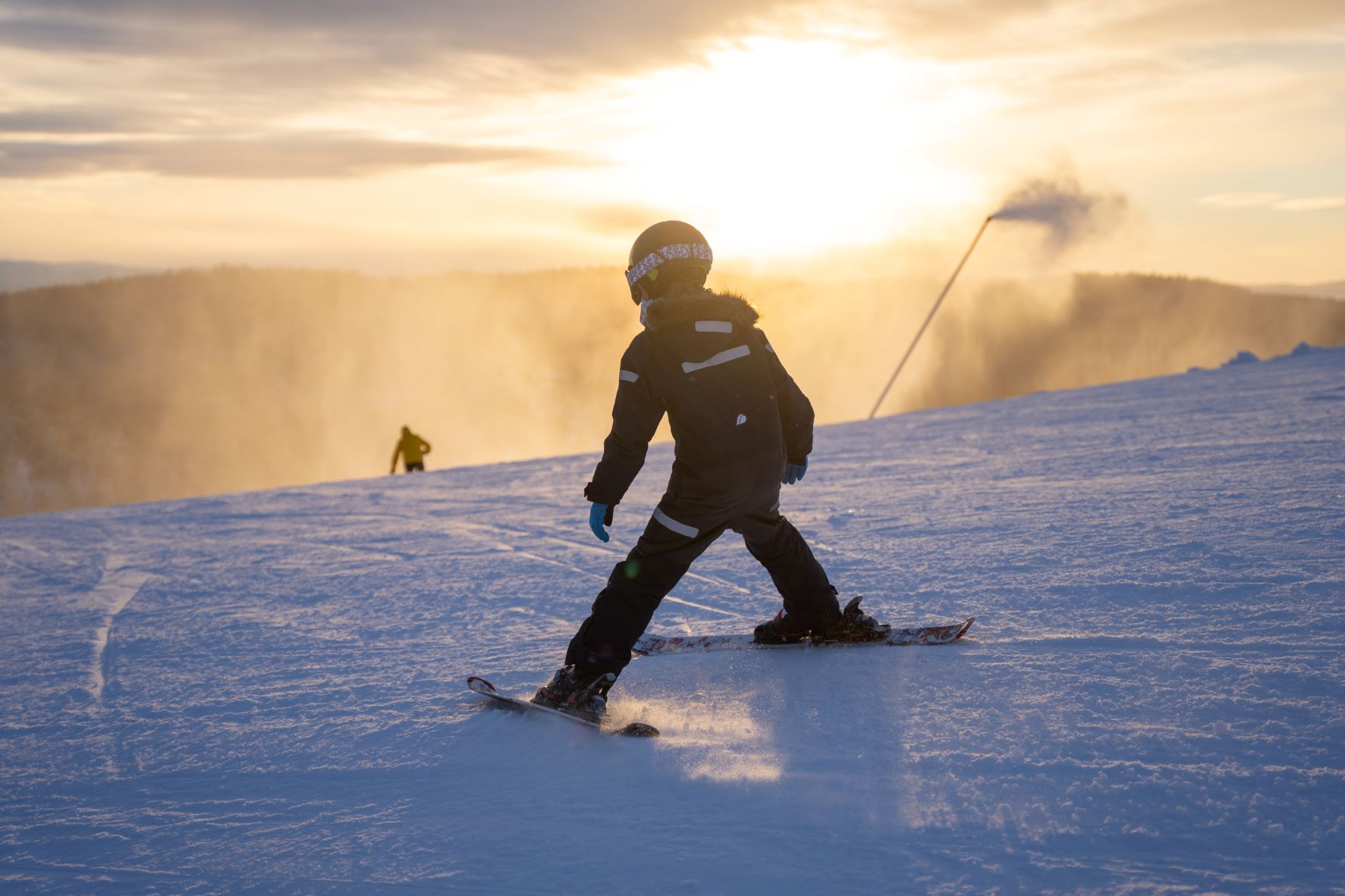 Pojke som åker slalom i solnedgången i Orsa Grönklitt