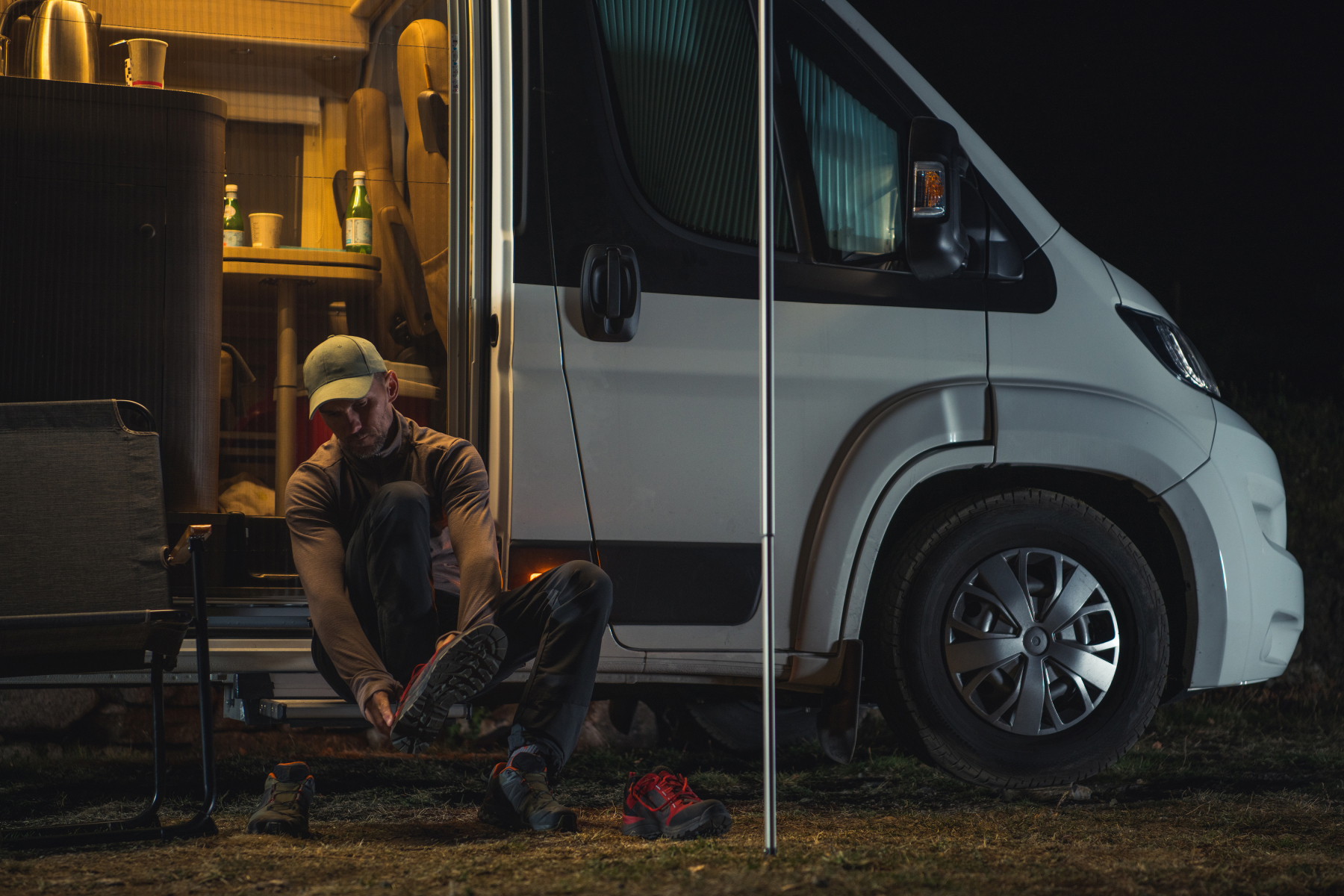 55467420 Hiker Changing Shoes In Front Of His Camper Van