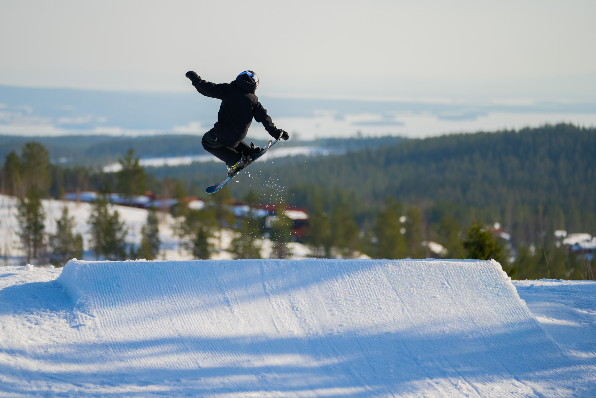 Pojke som hoppar med slalomskidor i snowparken i Orsa Grönklitt
