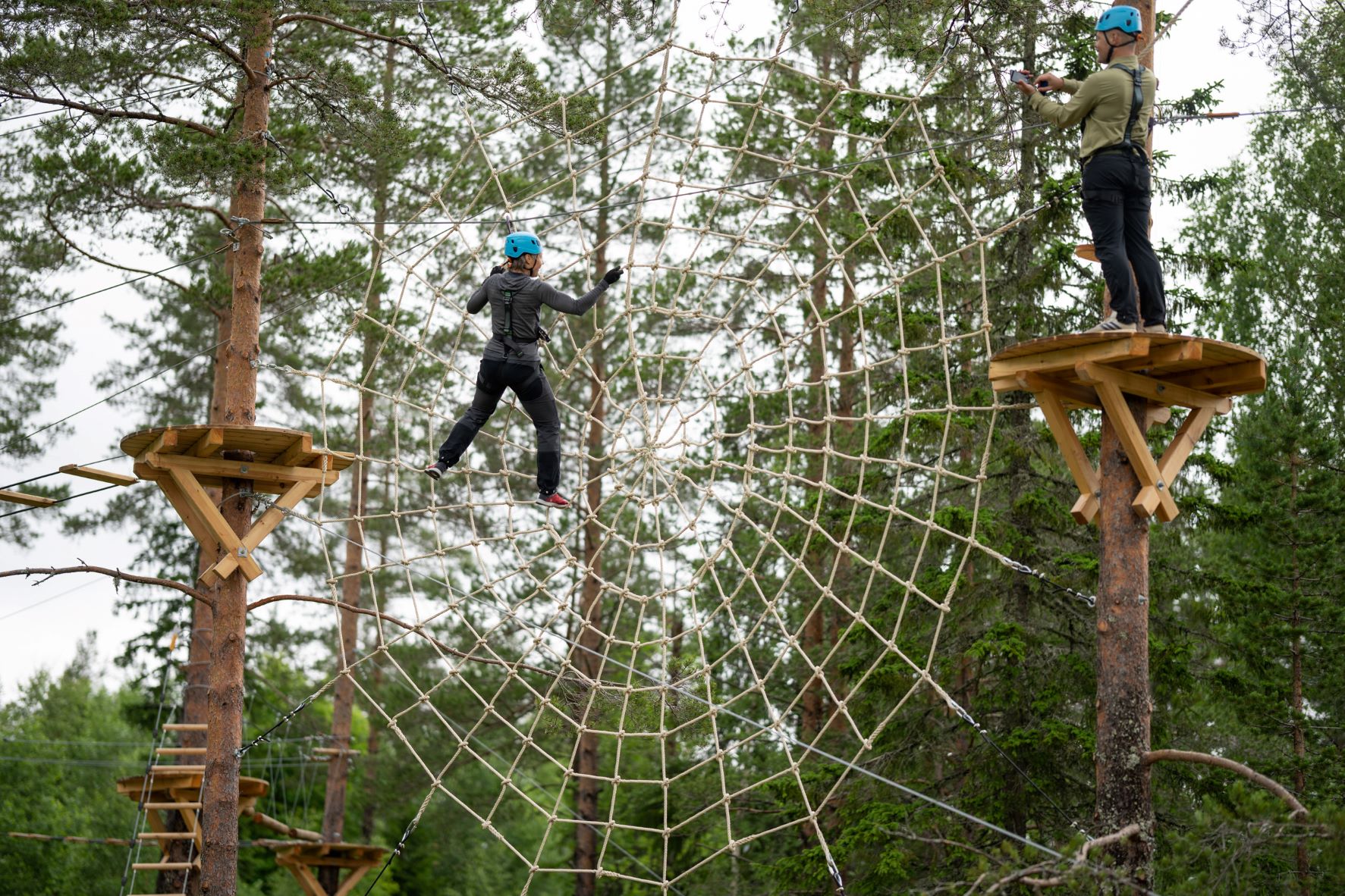 Tjej som klättrar i spindelnätet i Orsa Grönklitts Klätterpark