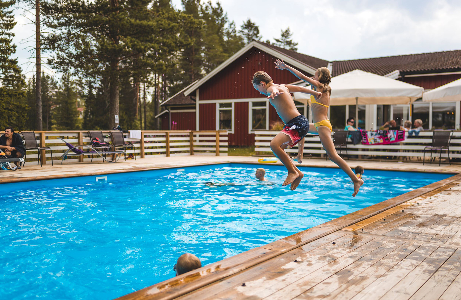 Barn som hoppar från poolkanten i Orsa Grönklitt