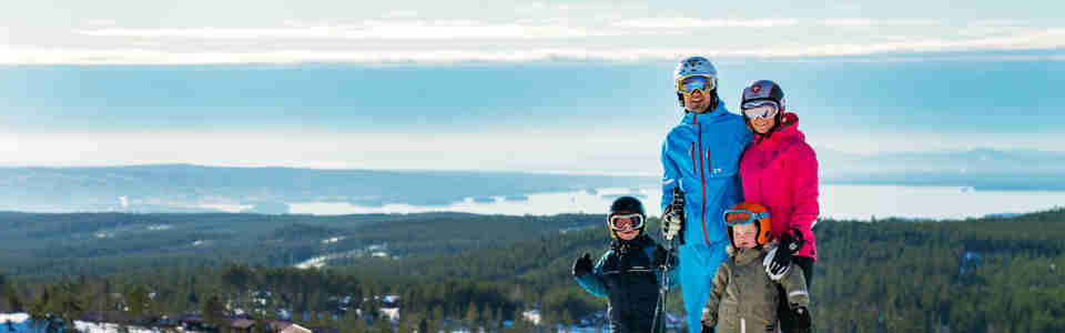 Barnfamilj som åker skidor