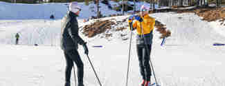 Skidlärare instruerar en längdåkare